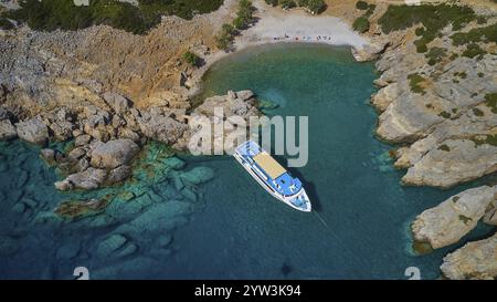 Palatia Beach, Palatia, bateau dans une petite baie avec de l'eau cristalline et les rochers environnants, tour en bateau Saria, île de Saria, Karpathos, Dodécanèse, Gree Banque D'Images