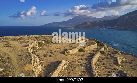 Tir de drone, site de fouilles archéologiques, paysage de ruines au bord de la mer avec vue lointaine sur les montagnes en arrière-plan, colline de l'acropole, ruines de A. Banque D'Images