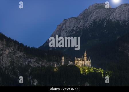 Château de Neuschwanstein dans les montagnes la nuit sous un ciel clair avec la lune, romantique, Schwangau, Ostallgaeu, Allgaeu, Souabe, haute-Bavière, Bavière Banque D'Images