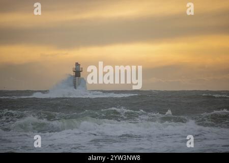 Un phare se dresse dans la tempête. Mer sauvage dans la soirée. Coucher de soleil sur une côte avec de nombreux rochers dans la mer du Nord. Paysage marin en Suède, Scandinavie Banque D'Images