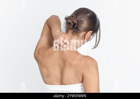 Douleur au cou, femme en serviette, isolé sur fond blanc, plan de studio. Vue arrière. Concept de santé Banque D'Images