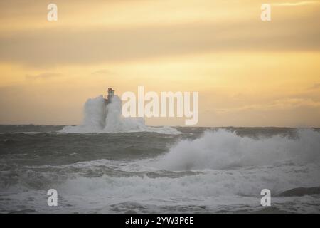Un phare se dresse dans la tempête. Mer sauvage dans la soirée. Coucher de soleil sur une côte avec de nombreux rochers dans la mer du Nord. Paysage marin en Suède, Scandinavie Banque D'Images
