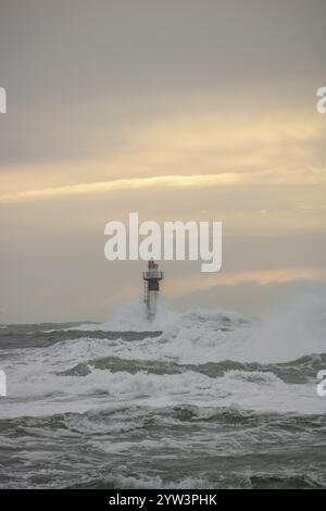 Un phare se dresse dans la tempête. Mer sauvage dans la soirée. Coucher de soleil sur une côte avec de nombreux rochers dans la mer du Nord. Paysage marin en Suède, Scandinavie Banque D'Images