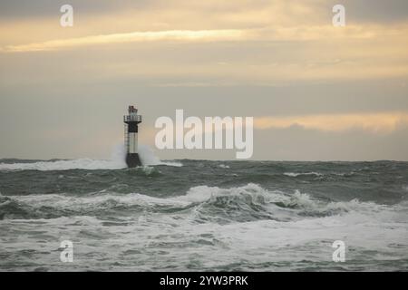 Un phare se dresse dans la tempête. Mer sauvage dans la soirée. Coucher de soleil sur une côte avec de nombreux rochers dans la mer du Nord. Paysage marin en Suède, Scandinavie Banque D'Images