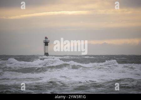 Un phare se dresse dans la tempête. Mer sauvage dans la soirée. Coucher de soleil sur une côte avec de nombreux rochers dans la mer du Nord. Paysage marin en Suède, Scandinavie Banque D'Images