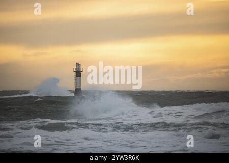 Un phare se dresse dans la tempête. Mer sauvage dans la soirée. Coucher de soleil sur une côte avec de nombreux rochers dans la mer du Nord. Paysage marin en Suède, Scandinavie Banque D'Images