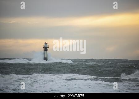 Un phare se dresse dans la tempête. Mer sauvage dans la soirée. Coucher de soleil sur une côte avec de nombreux rochers dans la mer du Nord. Paysage marin en Suède, Scandinavie Banque D'Images