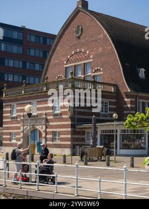 Musée maritime de Kiel qui se trouve dans l'ancien bâtiment de vente aux enchères de poissons en face de laquelle se trouvent 4 personnes parlant dont 2 en scooters électriques handicapés. Banque D'Images