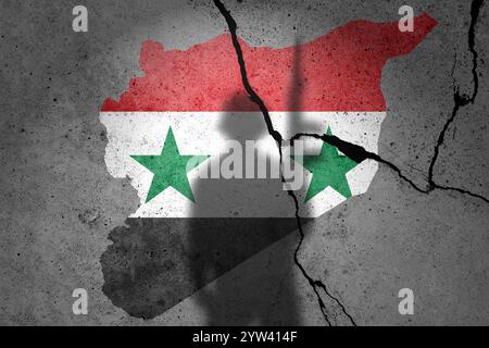 Drapeaux de Syrie peints sur un mur de béton fissuré avec l'ombre du soldat Banque D'Images