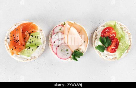 Assortiment gâteau de riz salé avec saumon, jambon, légumes frais. Collation sans gluten et à faible teneur en calories. Banque D'Images