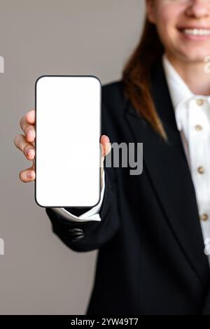 Téléphone intelligent avec écran vide dans la main de la personne féminine. Banque D'Images