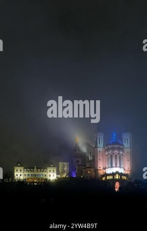 LYON, 8 décembre 2024 : basilique de Fourvière dans le brouillard pendant la Fête des lumières. Festival révèle la beauté de Lyon à la tombée de la nuit chaque année aroun Banque D'Images