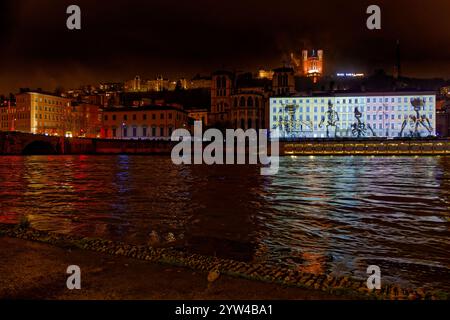 LYON, 8 décembre 2024 : Fête des lumières sur les quais de Saône avec basilique de Fourvière en arrière-plan. Festival révèle la beauté de Lyon au n° Banque D'Images