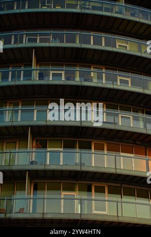 Bâtiment résidentiel rond moderne avec balcons au coucher du soleil. Architecture contemporaine au design incurvé. Style minimaliste de l'immeuble d'appartements Wit Banque D'Images