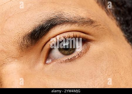 Bel homme capte l'attention avec son regard fascinant et ses caractéristiques attrayantes dans une lumière douce. Banque D'Images