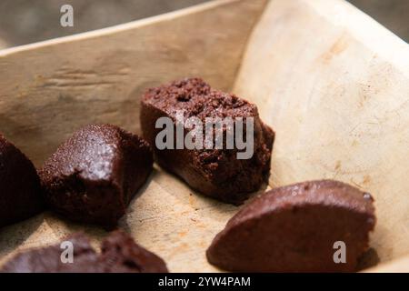 Chocolat biologique de la région de Oaxaca au Mexique produit de manière traditionnelle sur un métate, un outil en pierre ancien pour le broyage des produits. Banque D'Images