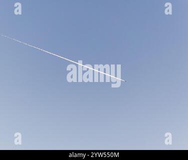 Traînées d'un avion volant dans le ciel bleu au-dessus de Worthing, West Sussex, Royaume-Uni Banque D'Images