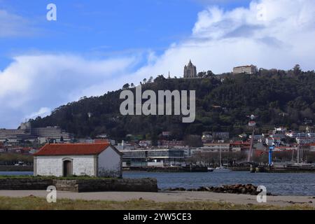 Viana do Castelo, Portugal - 2 mars 2024 : vue panoramique sur le sanctuaire de Santa Luzia au sommet d'une colline boisée avec la rivière Lima et une construction pittoresque au bord de la rivière Banque D'Images
