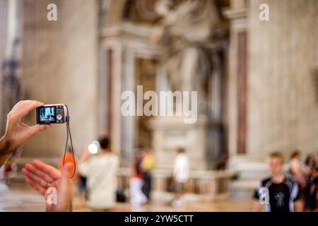 Rome, Italie, le 22 juillet 2017, Un visiteur prend des photos à l'intérieur de la grande basilique Saint-Pierre de la Cité du Vatican, entouré d'autres touristes explorant t Banque D'Images