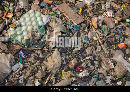 Des déchets plastiques de divers types recouvrent un canal à Dhaka, au Bangladesh, mettant en évidence un problème environnemental urgent. Banque D'Images
