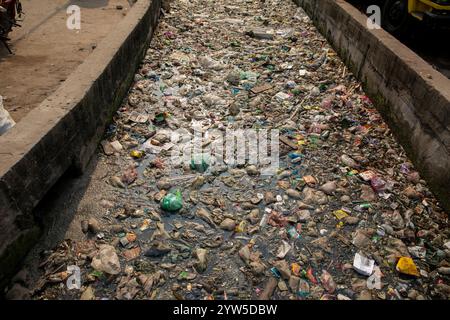 Des déchets plastiques de divers types recouvrent un canal à Dhaka, au Bangladesh, mettant en évidence un problème environnemental urgent. Banque D'Images