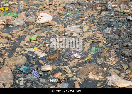 Des déchets plastiques de divers types recouvrent un canal à Dhaka, au Bangladesh, mettant en évidence un problème environnemental urgent. Banque D'Images