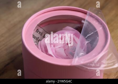 Une bougie en forme de fleur dans une mini boîte avec une fenêtre dans le couvercle. Emballage cadeau. Gros plan Banque D'Images