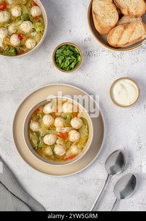 Photographie alimentaire de soupe avec boulettes de poulet et légumes, carottes, chou, brocoli, pommes de terre, poivron, bouillon, pain grillé, oignon de printemps, Banque D'Images