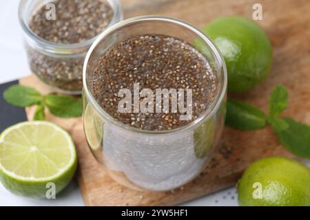 Verre de boisson avec des graines de chia et citron vert sur la table blanche, gros plan Banque D'Images