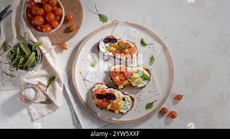 Bruschettas italiens avec tomates rôties, mozzarella, tranches d'ananas et herbes sur un comptoir de cuisine rustique. Banque D'Images