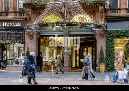 Le mouvement des acheteurs de Noël est devenu flou lorsqu'ils passent devant l'entrée d'Argyll Arcade sur Buchanan Street, Glasgow, Écosse, Royaume-Uni, Europe Banque D'Images