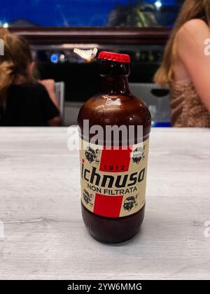 Porto Sant'Elpidio, Italie - 06 juillet 2022 : une image focalisée d'une bouteille de bière Ichnusa avec un bouchon rouge sur une table aux tons clairs, serrée contre un même flou Banque D'Images