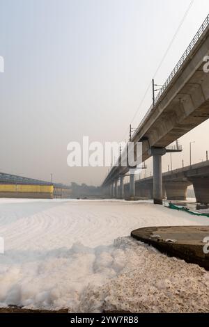 rivière polluée avec effluents industriels et domestiques mousse toxique et pont routier à l'image du matin est prise à yamuna river okhla barrage delhi inde. Banque D'Images