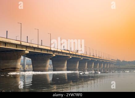 pont routier avec rivière polluée avec effluents industriels et domestiques mousse toxique au lever du soleil image est prise à yamuna rivière okhla barrage delhi inde. Banque D'Images