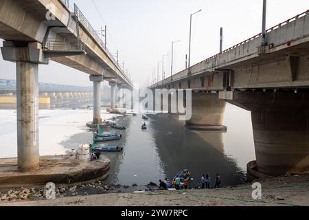 Pont routier moderne enjambant la rivière contaminée avec la mousse toxique et le bateau de travailleurs à brumeux matin vidéo est prise à yamuna rivière okhla barrage delhi Banque D'Images