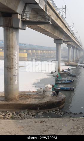 Pont routier moderne enjambant la rivière contaminée avec la mousse toxique et le bateau de travailleurs à brumeux matin vidéo est prise à yamuna rivière okhla barrage delhi Banque D'Images