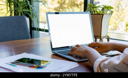 La main de la femme utilise l'ordinateur portable et le regarde, tablette à écran blanc avec fond blanc pour le texte publicitaire, humain utilisant la recherche d'entreprise de contact d'ordinateur portable dans Banque D'Images