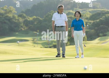 Senior couple walking on golf course Banque D'Images