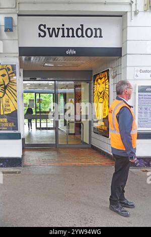 Plate-forme de la gare ferroviaire de Swindon homme au travail gérant l'arrivée et le départ en toute sécurité des passagers à la propriété Great Western Railway dans le Wiltshire Angleterre Royaume-Uni Banque D'Images