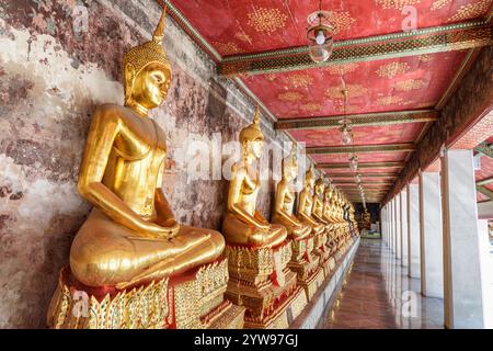 Rangée de statues de Bouddha dorées à Wat Suthat Thepwararam, Bangkok Banque D'Images