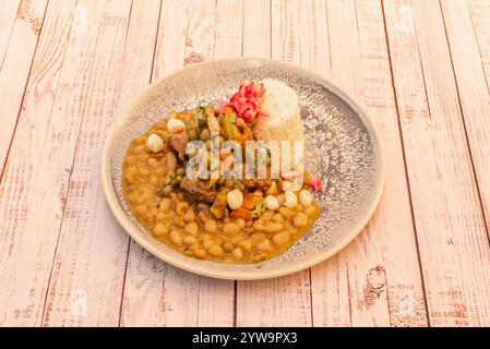 Une assiette de haricots avec riz, maïs et sauce Chili épicée Banque D'Images