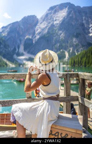 Jeune femme portant un chapeau de paille admirant le magnifique paysage du lac de braies dans les dolomites italiennes lors d'une journée d'été ensoleillée Banque D'Images