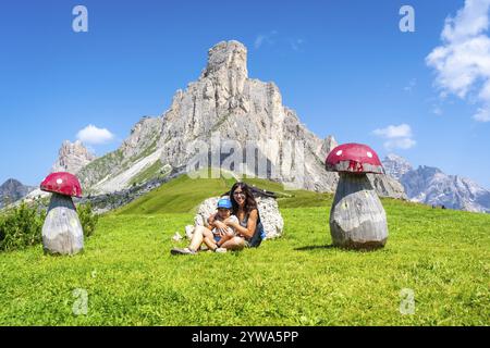 Mère et enfant se reposent près de champignons en bois au col de giau, un col de haute montagne dans les dolomites, en italie Banque D'Images