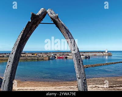 Royaume-Uni, Northumberland, Seahouses, Whale Jaw Bones surplombant l'entrée du port de North Sunderland et le phare. Banque D'Images