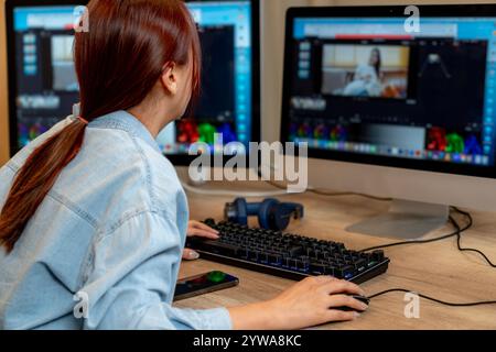 Une jeune femme éditant des vidéos à la maison Banque D'Images