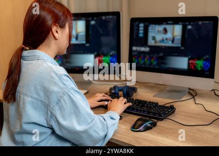 Une jeune femme éditant des vidéos à la maison Banque D'Images