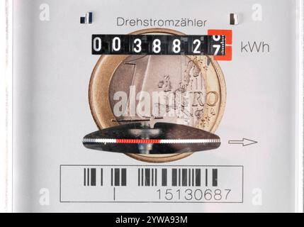 Stromzähler und Stromkosten Eine Euromünze ist auf einem Stromzähler überblendet, als Symbolbild für Hohe Stromkosten und Energieverbrauch - FOTOMONTA Banque D'Images