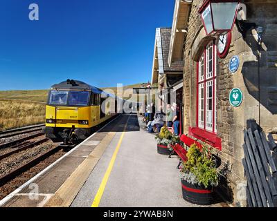 UK, North Yorkshire, Yorkshire Dales, gare ferroviaire de Ribblehead, locomotive de fret de classe 60 passant par la gare. Banque D'Images