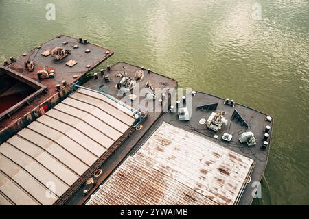 Une barge, bateau à fond plat, poussé par un remorqueur le long de la rivière pour le transport, vue en angle élevé Banque D'Images