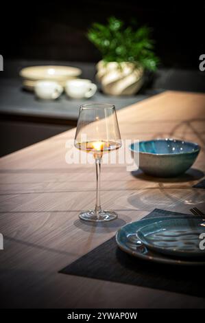 Élégant verre à vin rose qui brille sur un comptoir de cuisine moderne, ajoutant une touche de sophistication à la table à manger Banque D'Images